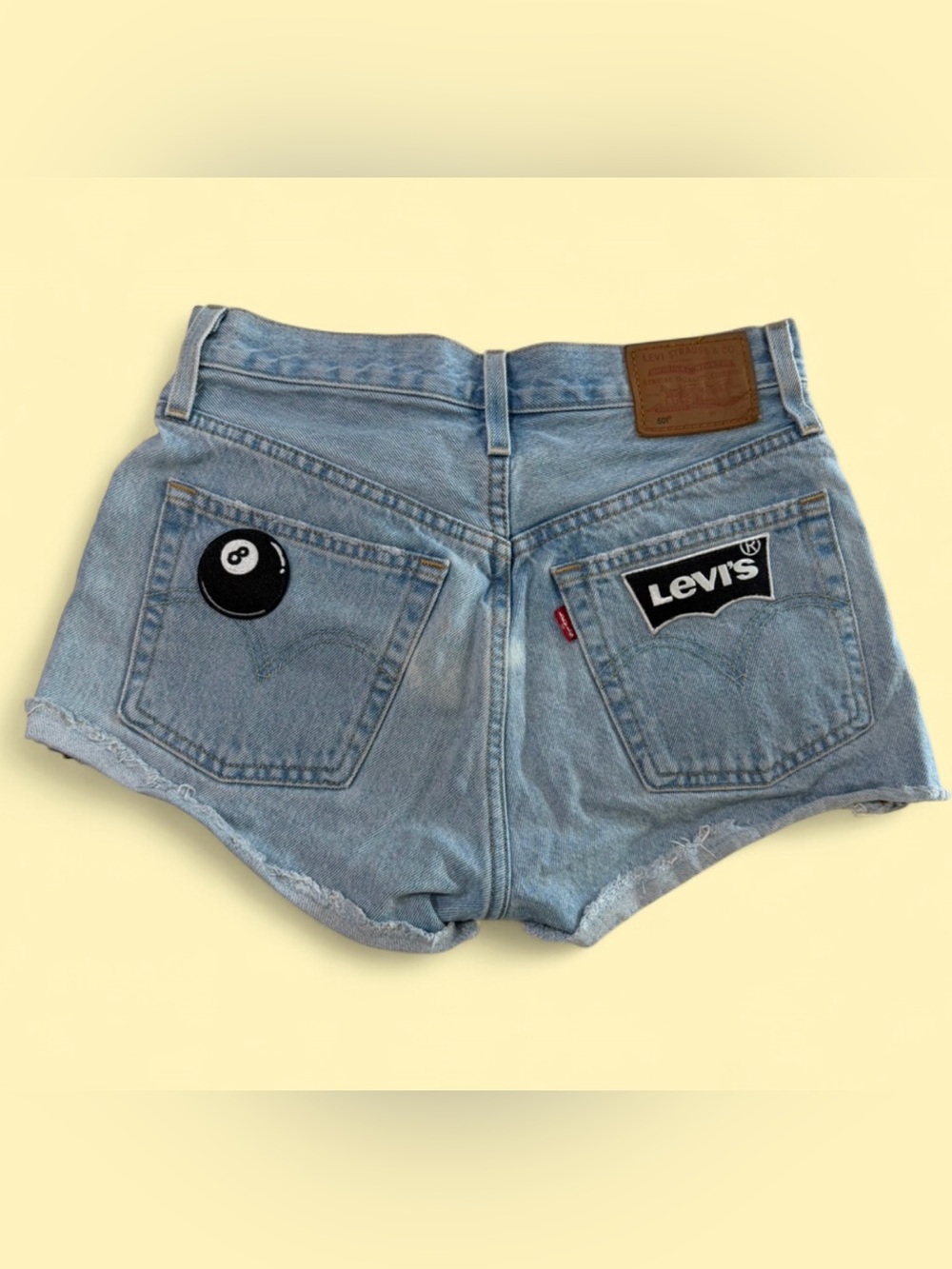 Levi's 501 denim shorts feature custom 8-ball and logo patches.